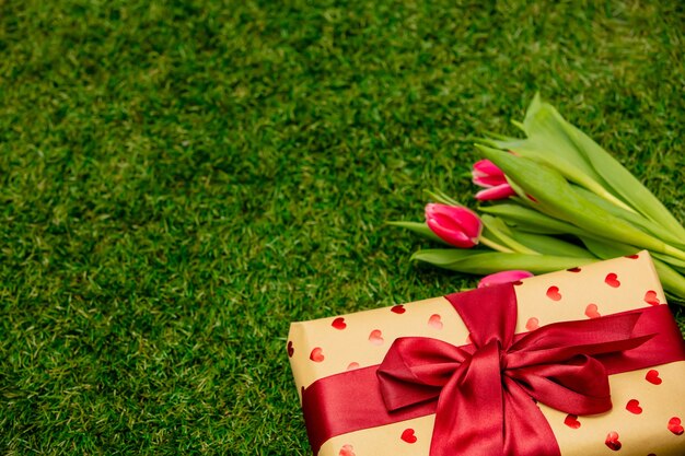 Geschenkbox mit Tulpen auf grünem Gras in einem Garten