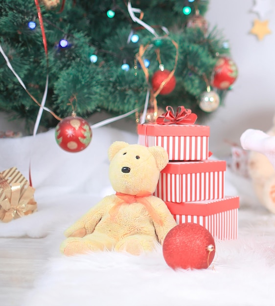 Geschenkbox und Kuscheltier unter dem Weihnachtsbaum hautnah