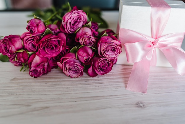 Geschenkbox und rosa Rosen auf Holzhintergrund Postkarte Platz für Textnachricht Blumenkonzept Feiertagsgrußkarte für Valentinstag Frauen Muttertag Ostern alles Gute zum Geburtstag Hochzeitseinladung