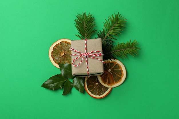 Geschenkbox und Weihnachtsaccessoires auf grünem Hintergrund