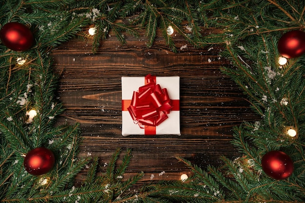 Geschenkbox und Weihnachtsgirlande auf Holzuntergrund