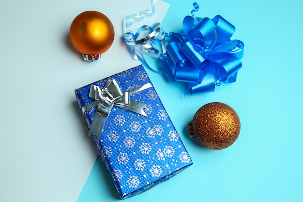 Foto geschenkbox- und weihnachtsverzierungen auf einem blauen hintergrund