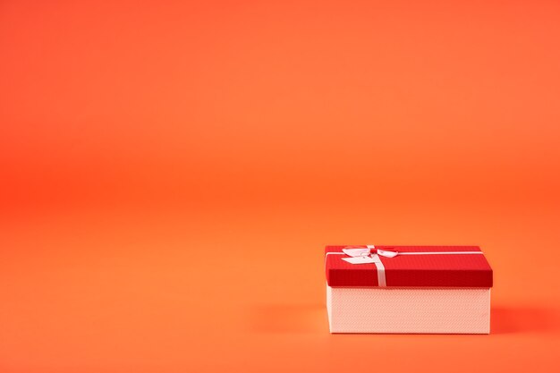 Geschenkbox zu Weihnachten auf orangem Hintergrund