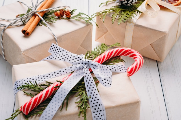 Geschenkboxen in Geschenkpapier mit Bändern, Tannenzapfen und getrockneten Orangen eingewickelt