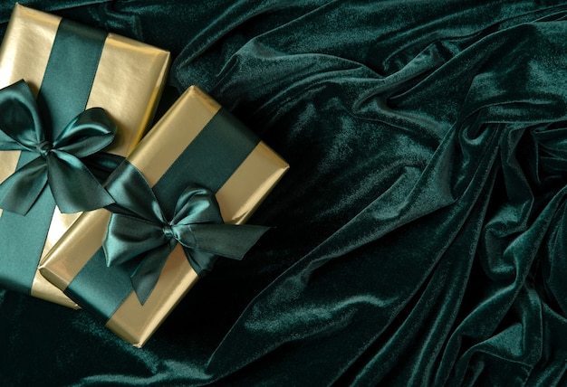 Geschenkboxen in Goldpapier mit gezeitengrünen Satinbändern.