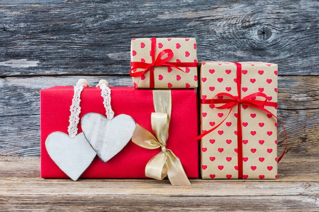 Geschenkboxen mit Herzen auf hölzernem Hintergrund. Platz kopieren. Valentinstag-Konzept.