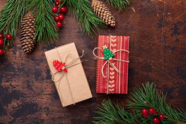 Geschenkboxen und Tannenbaumaste auf hölzernem Hintergrund. Weihnachtsgrußkarte. Ansicht von oben. copyspace
