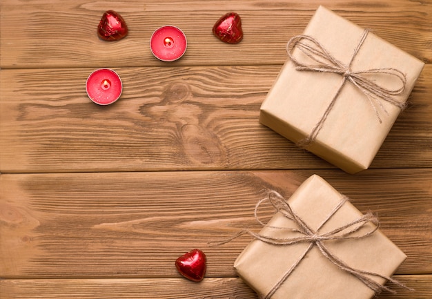 Geschenke auf einem Holztisch. In der Nähe von Süßigkeiten und Bonbons. Es gibt einen Text. Valentinstag Feier Konzept.