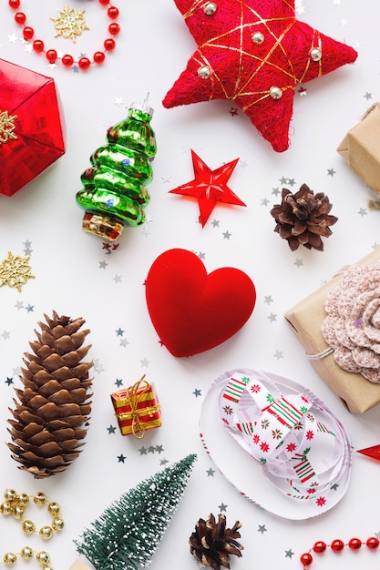 Geschenke aus Kraftpapier, Tannenzapfen, roten Herzen und Konfetti.