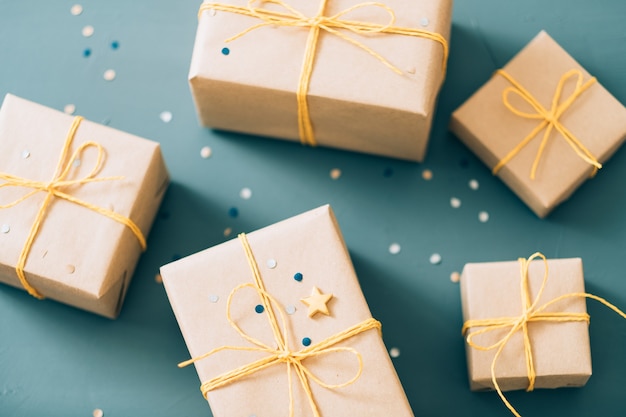 Geschenke für Freunde und Familie. Auswahl an Geschenken in handgefertigter Papierverpackung und mit gelber Schnur gebunden.