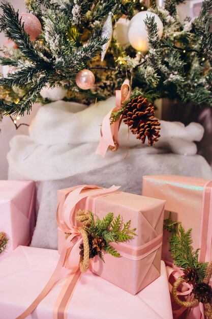 Geschenke unter dem Weihnachtsbaum, rosa Kisten mit Bändern verziert