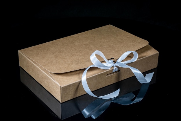 Geschenkkiste für Männer mit Luxusbogen auf dunklem Hintergrund Horizontal mit Kopierplatz