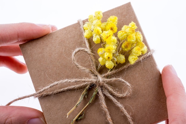 Geschenkkiste mit Blumen in der Hand
