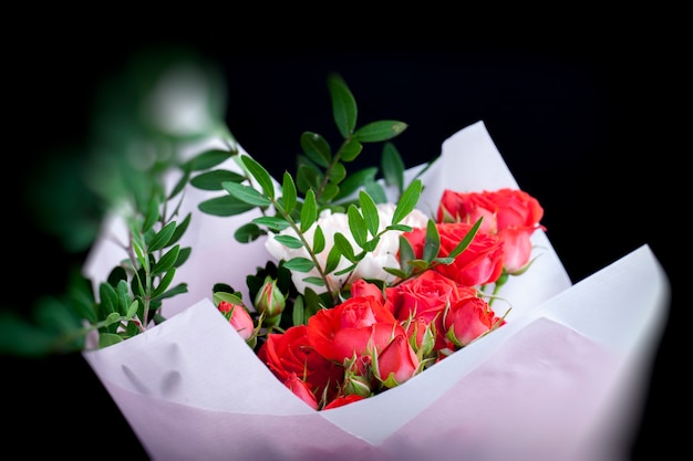 Geschenkstrauß mit roten Rosen und rosa Nelken, schöne Blumen zum Verschenken