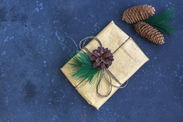 Geschenkverpackung im Kraftpapier mit Weihnachtsdekoration auf einem dunklen Hintergrund