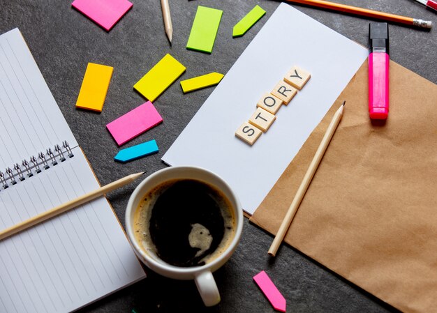 Geschichtenbriefe auf Papierblatt und Notizen mit Kaffeetasse auf einem Tisch