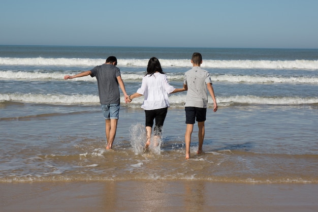 Geschiedene Mutter, die Spaß mit ihrem zwei Teenager auf dem Strand hat