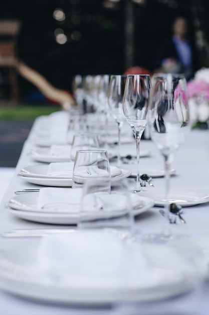 Geschirr Gläser Blumengabelmesser zum Abendessen im Restaurant mit gemütlichem Interieur serviert