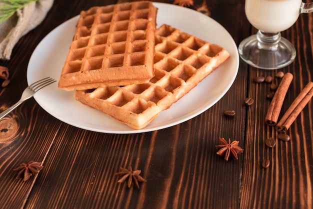 Geschmackvolle frische Wiener Oblaten, Stau und Tasse Kaffee auf einem dunklen hölzernen Hintergrund