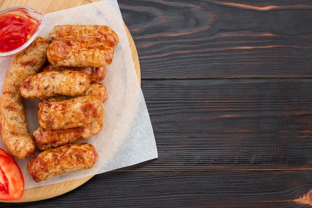 Geschmackvolle gegrillte Wurst auf dem hölzernen Hintergrund. Draufsicht mit Kopienraum.