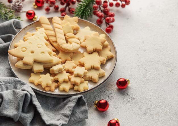 Foto geschmackvolle hausgemachte weihnachtskekse, gebackene traditionelle ingwerbrotkekse und dekorationen