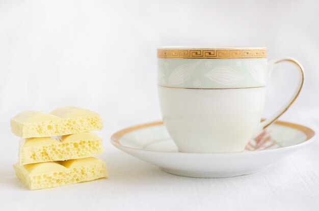 Geschmackvolle weiße poröse Schokolade und Tasse Kaffee