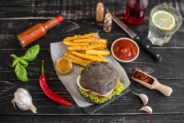 Geschmackvoller Hamburger mit Fleisch und Gemüse gegen einen dunklen Hintergrund. Fast Food. Es kann als Hintergrund verwendet werden