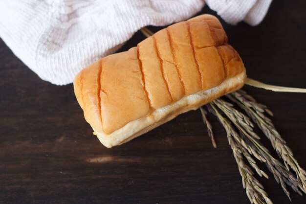 Geschmackvolles Brötchen auf dunklem hölzernem Brett.