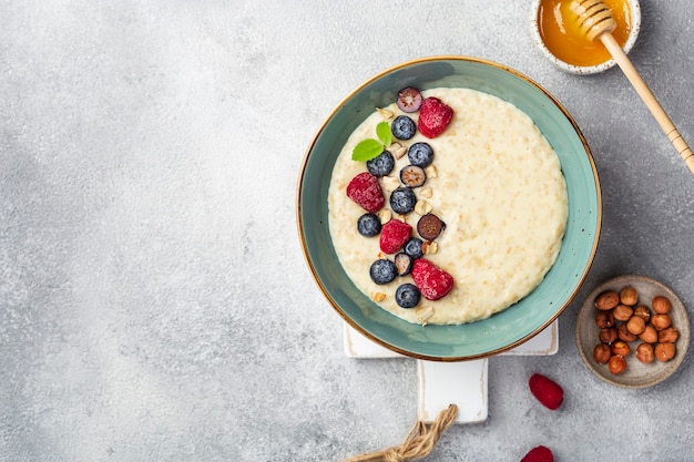 Geschmackvolles Hafermehl mit Beeren in einer Schüssel auf weißem Hintergrund