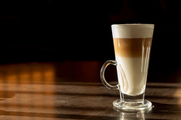 Foto geschmackvolles macchiato der nahaufnahme mit milch auf dem tisch