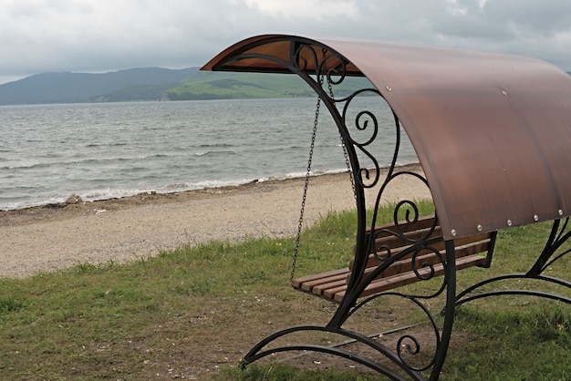 Geschmiedete Schaukel mit Dach am Meer.