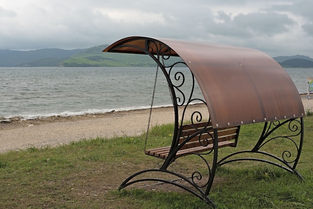 Geschmiedete Schaukel mit Dach am Meer.