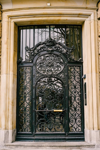 Geschmiedete Tür mit Glaseinsätzen an der Fassade eines Marmorgebäudes
