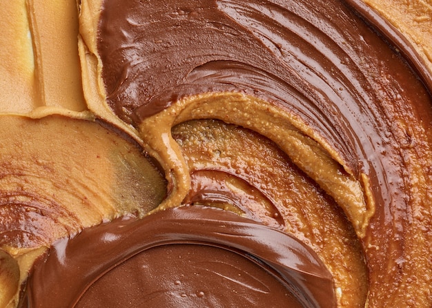 Geschmolzene Schokoladen-Haselnuss-Creme und Erdnussbutter-Hintergrund, Ansicht von oben