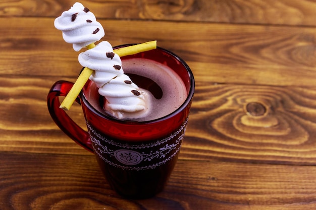 Geschmolzener Marshmallow-Schneemann in einer Tasse heißer Schokolade auf Holztisch