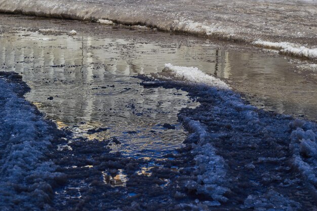 Geschmolzener Pfützenschlammschnee und Schmutz im Gelände