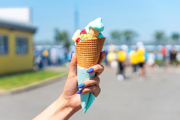 Geschmolzenes Eis aus dem heißen Sommerwetter in einer Frauenhand auf dem Hintergrund einer Stadtstraße