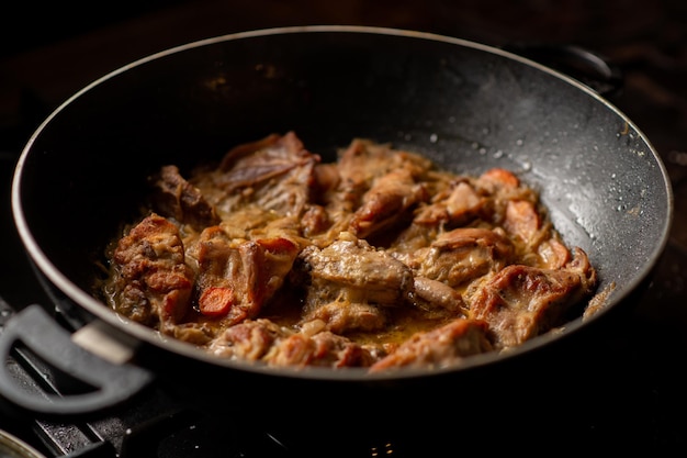 Geschmortes Kaninchen in einer Pfanne Kaninchen gekocht mit Zwiebeln und Karotten