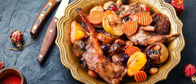 Geschmortes Kaninchenfleisch mit Früchten. Gebackenes Fleisch für den Weihnachtstisch. Weihnachtsgericht.