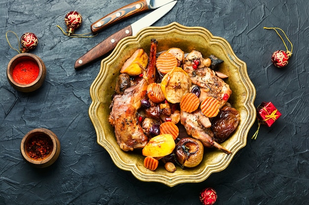 Geschmortes Kaninchenfleisch mit Früchten. Gebackenes Fleisch für den Weihnachtstisch. Weihnachtsgericht.