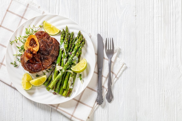 Foto geschmortes ossobuco mit gegrilltem spargel von oben