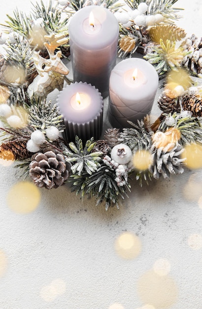 Geschmückter Adventskranz aus Tannenzweigen und immergrünen Zweigen mit brennenden Kerzen Tradition in der Vorweihnachtszeit