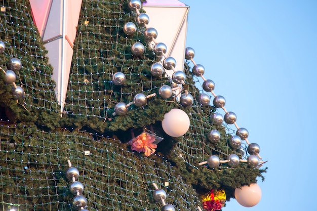 Geschmückter Weihnachtsbaum auf dem Hintergrund des blauen Himmels. Teil der großen Weihnachtsbaumnahaufnahme im Freien