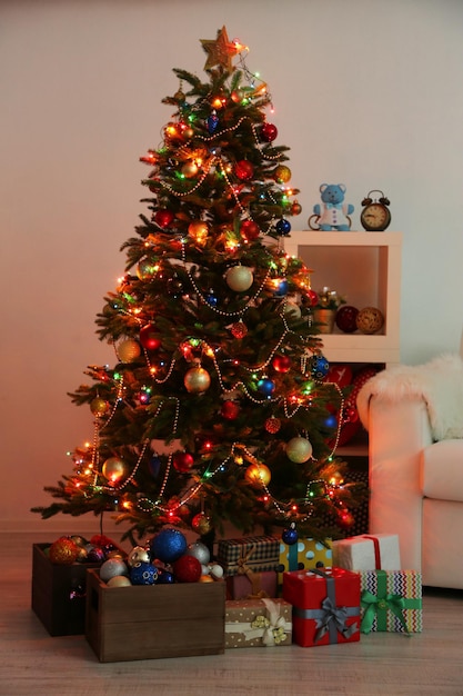 Geschmückter Weihnachtsbaum auf Innenhintergrund in der Nacht