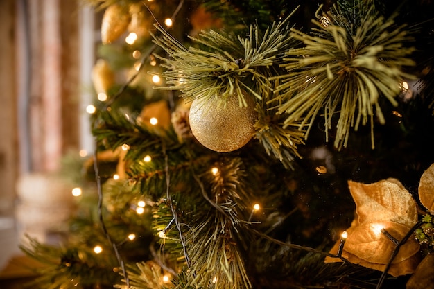 Geschmückter Weihnachtsbaum auf unscharfem, funkelnden und feenhaften Hintergrund. Festliche Zweige mit Kugeln