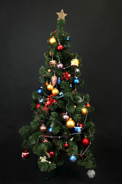 Geschmückter Weihnachtsbaum isoliert auf schwarz