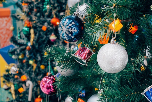 Geschmückter Weihnachtsbaum mit bunter Kugel auf funkelnden Bokeh-Licht unscharfem Hintergrund