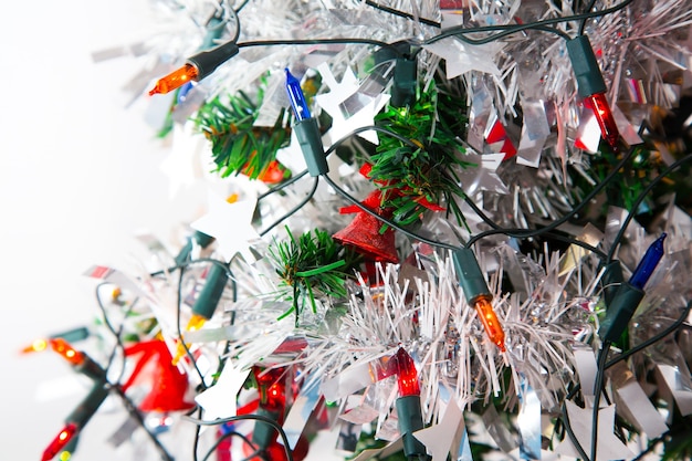 Geschmückter Weihnachtsbaum mit rotem Ball und buntem Ornament auf weißem Hintergrund mit Kopierraum