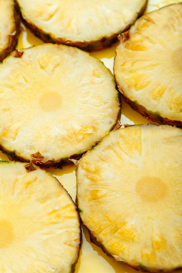 Geschnittene Ananaskreise Hintergrund. Lebensmittelfrucht tropische gelbe Sommerhintergrundoberflächenbeschaffenheit. Ananas-Muster. Vertikal Hochwertiges Stockfotos