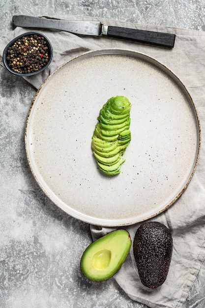 Geschnittene Avocado auf einer Lehmplatte.